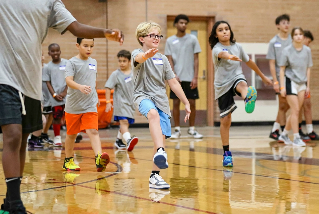 Diverse group of youth basketball players laughing together on the court