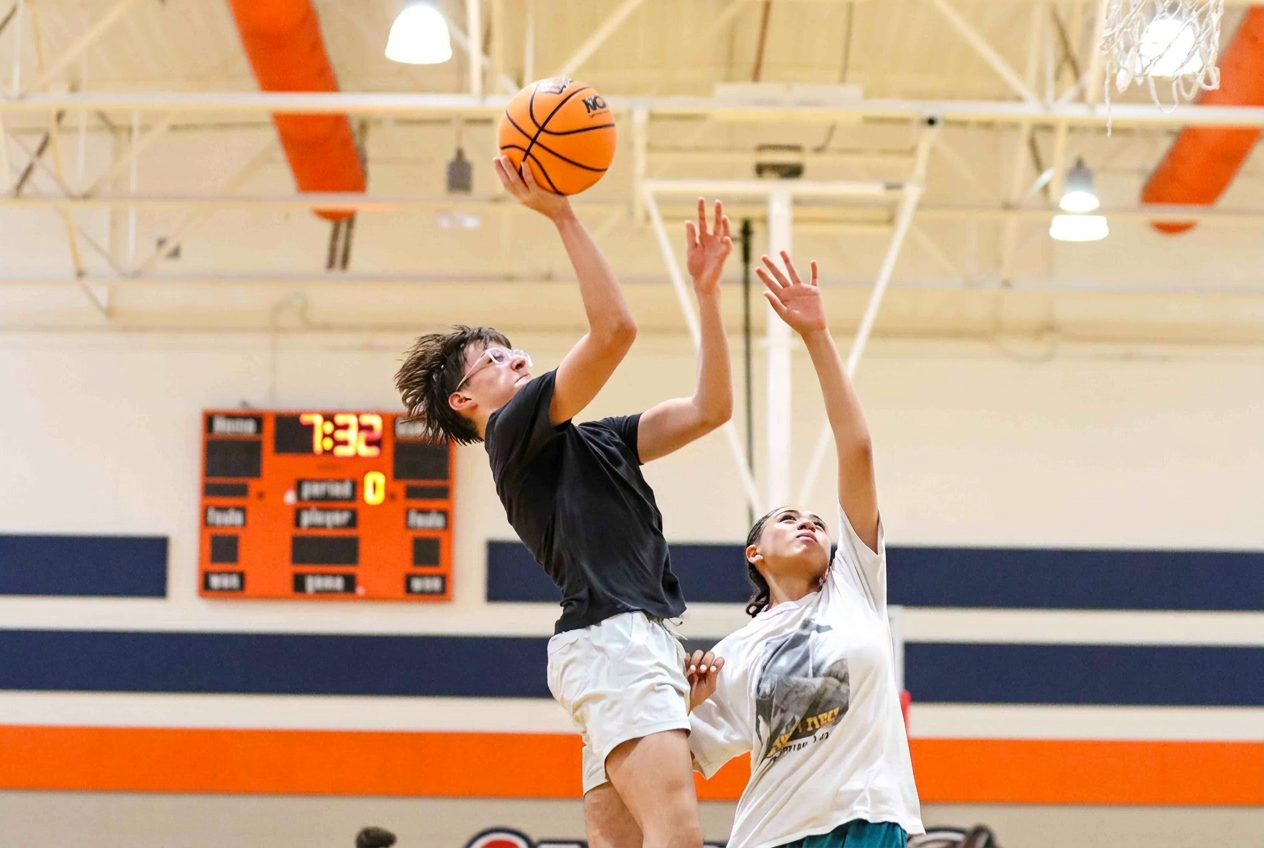 Player going up for a layup with a defender contesting
