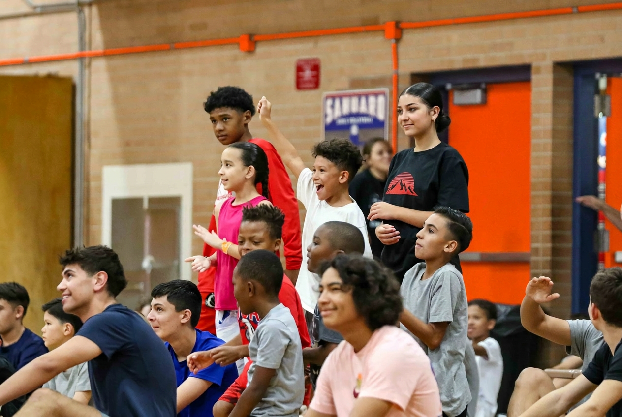 Group of kids cheering on the sideline at Jumpstart Hoops